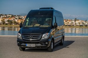 A luxurious black Mercedes Sprinter VIP minibus with tinted windows and leather seats.
