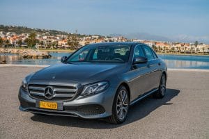A sleek Mercedes E-Class taxi parked in a scenic location in Crete.